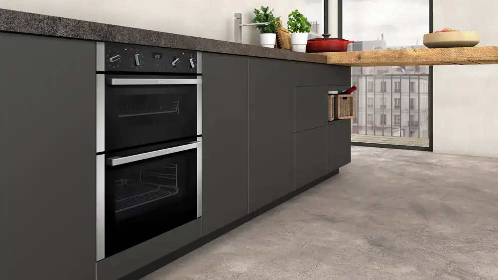 a neff oven within a grey handless kitchen base unit